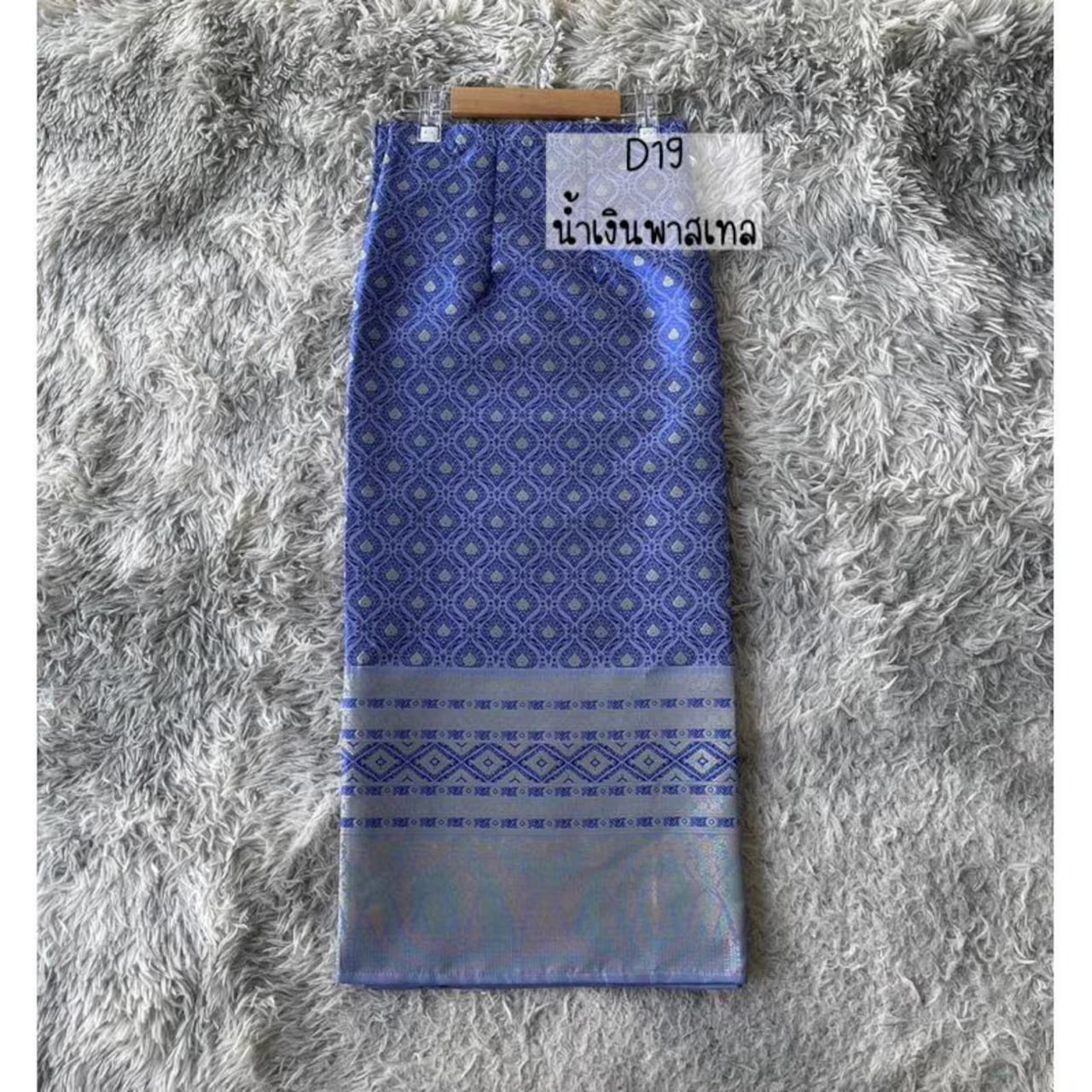 The "Lavender Gleam – Traditional Laotian Handwoven Sinh Skirt" features a graceful blend of deep lavender-blue hues and traditional