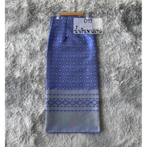 The "Lavender Gleam – Traditional Laotian Handwoven Sinh Skirt" features a graceful blend of deep lavender-blue hues and traditional